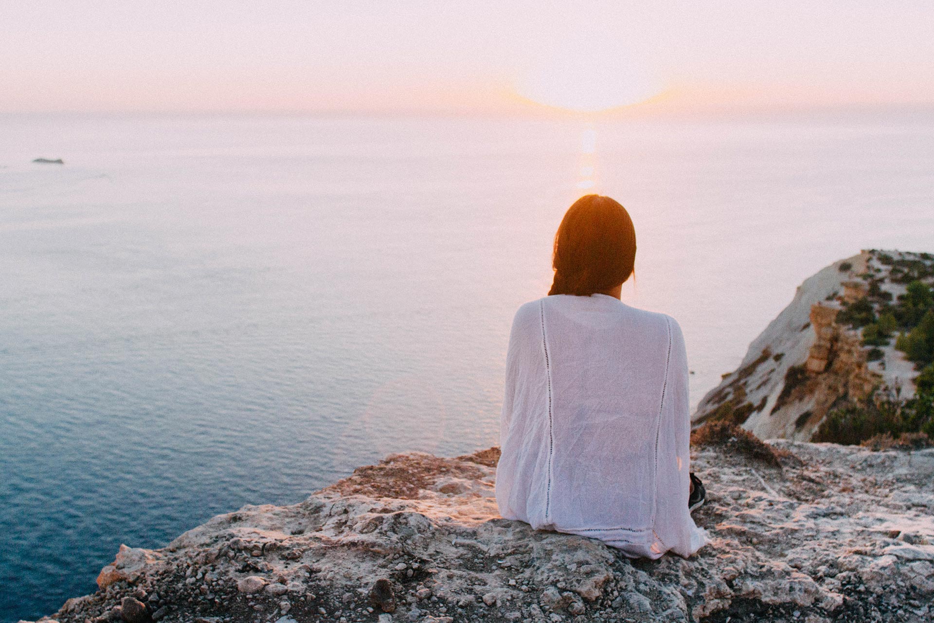 Person sitting quietly overlooking the sea